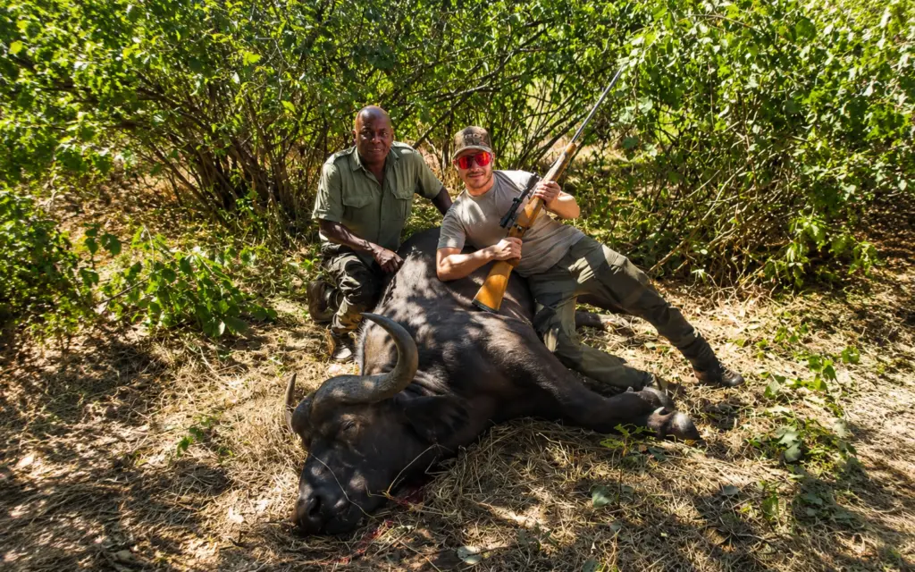 Client and professional guide posing with a buffalo trophy in Zimbabwe